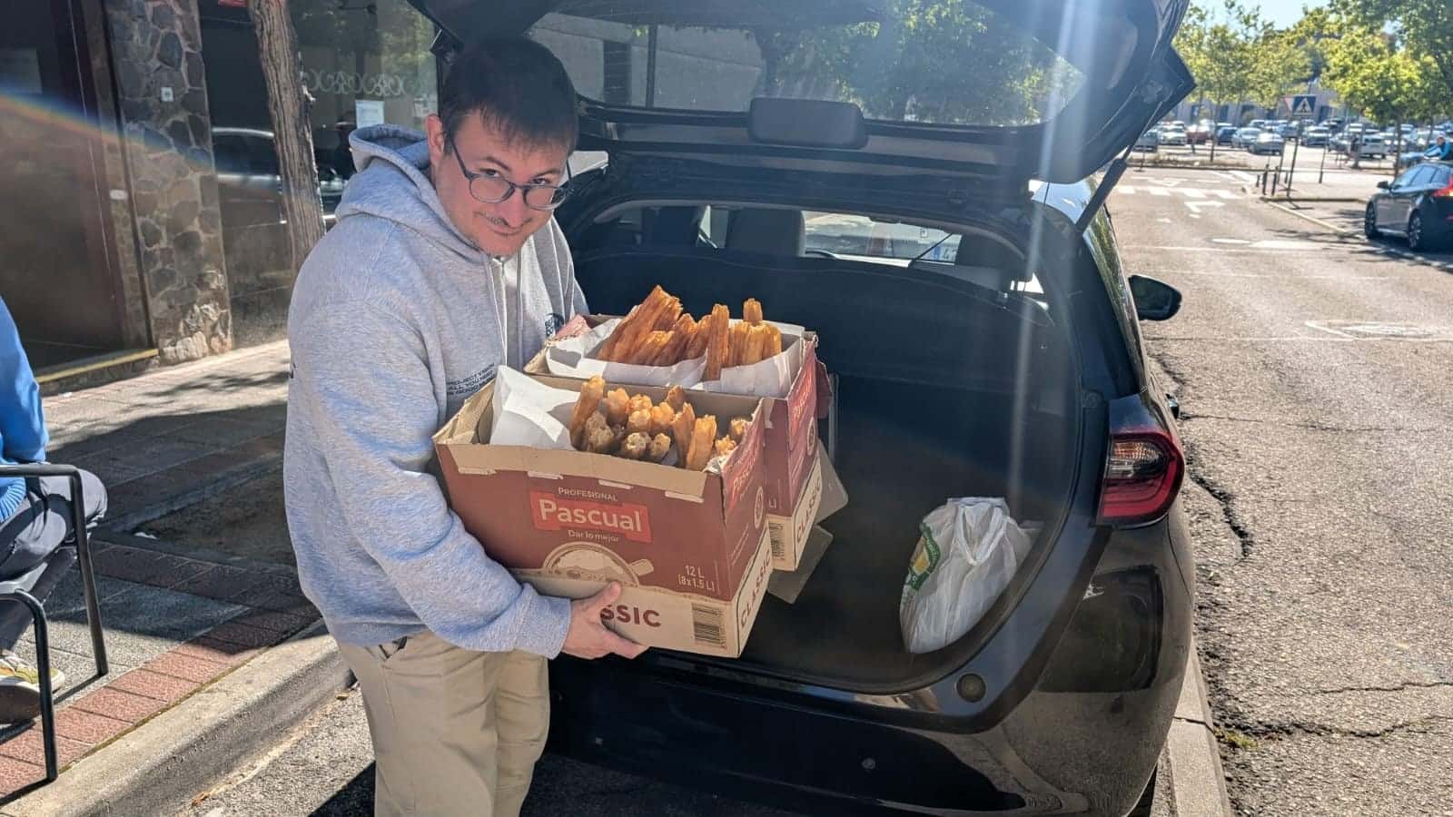 Un voluntario descarga cajas de churros para el desayuno del domingo